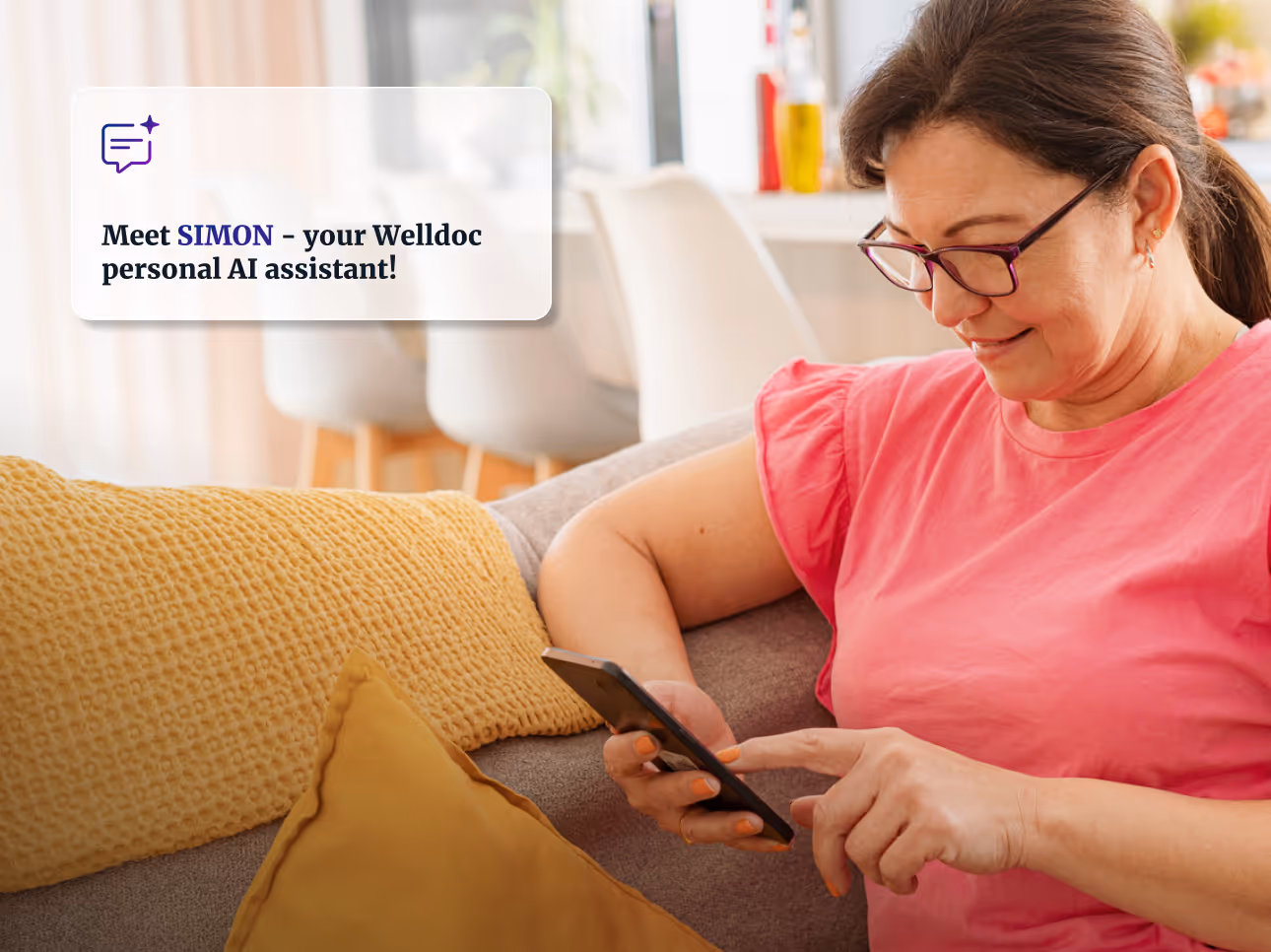 Woman in pink shirt sitting on a couch with yellow pillows, smiling while using a smartphone.