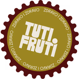 Round fruit-flavored candy logo with a red gear-shaped border, olive green center, and white text 'TUTI FRUTI' surrounded by repeated word 'ZDRAVO'.
