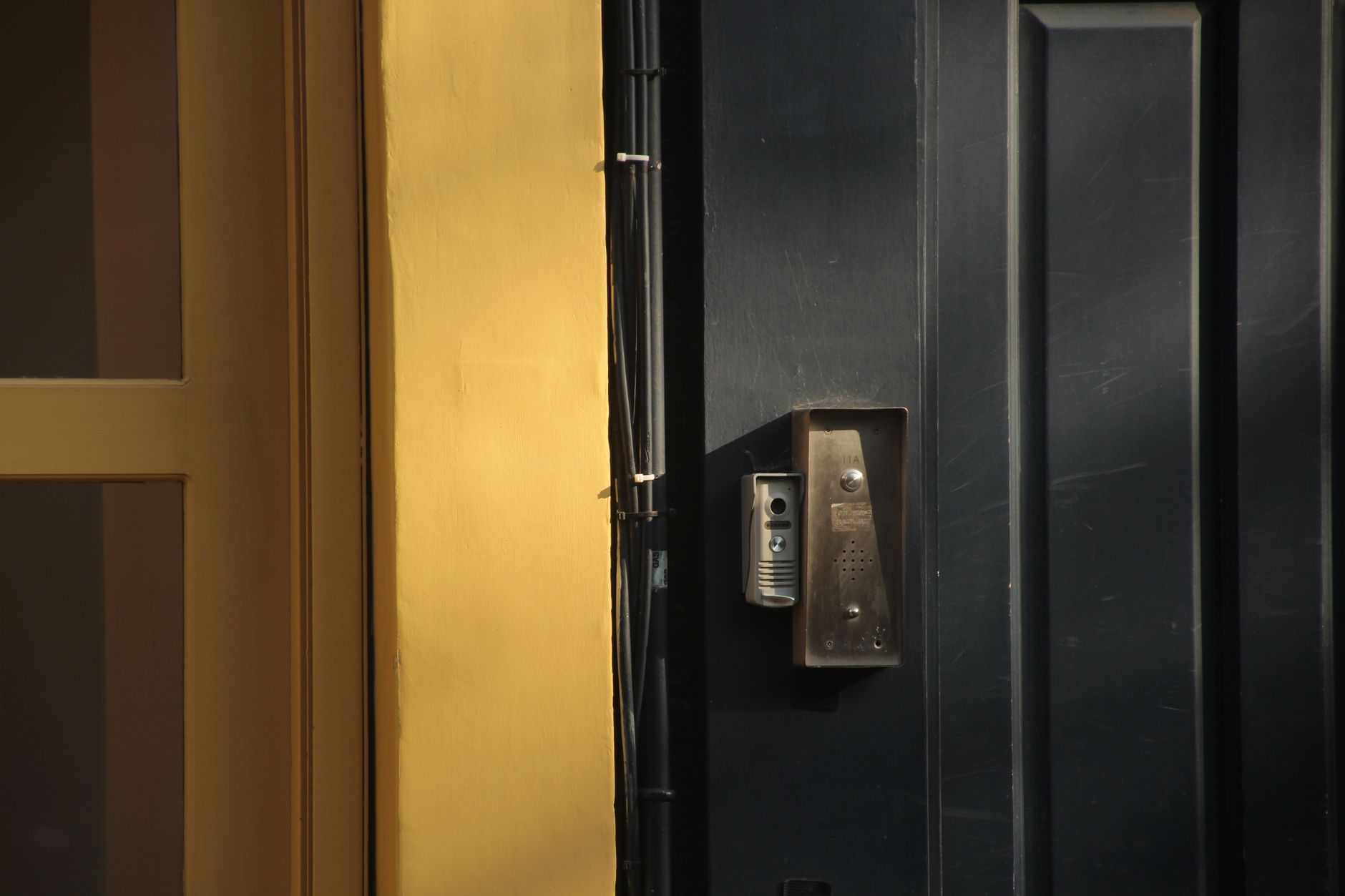Ancien interphone audio installé sur une porte d'immeuble à Bruxelles