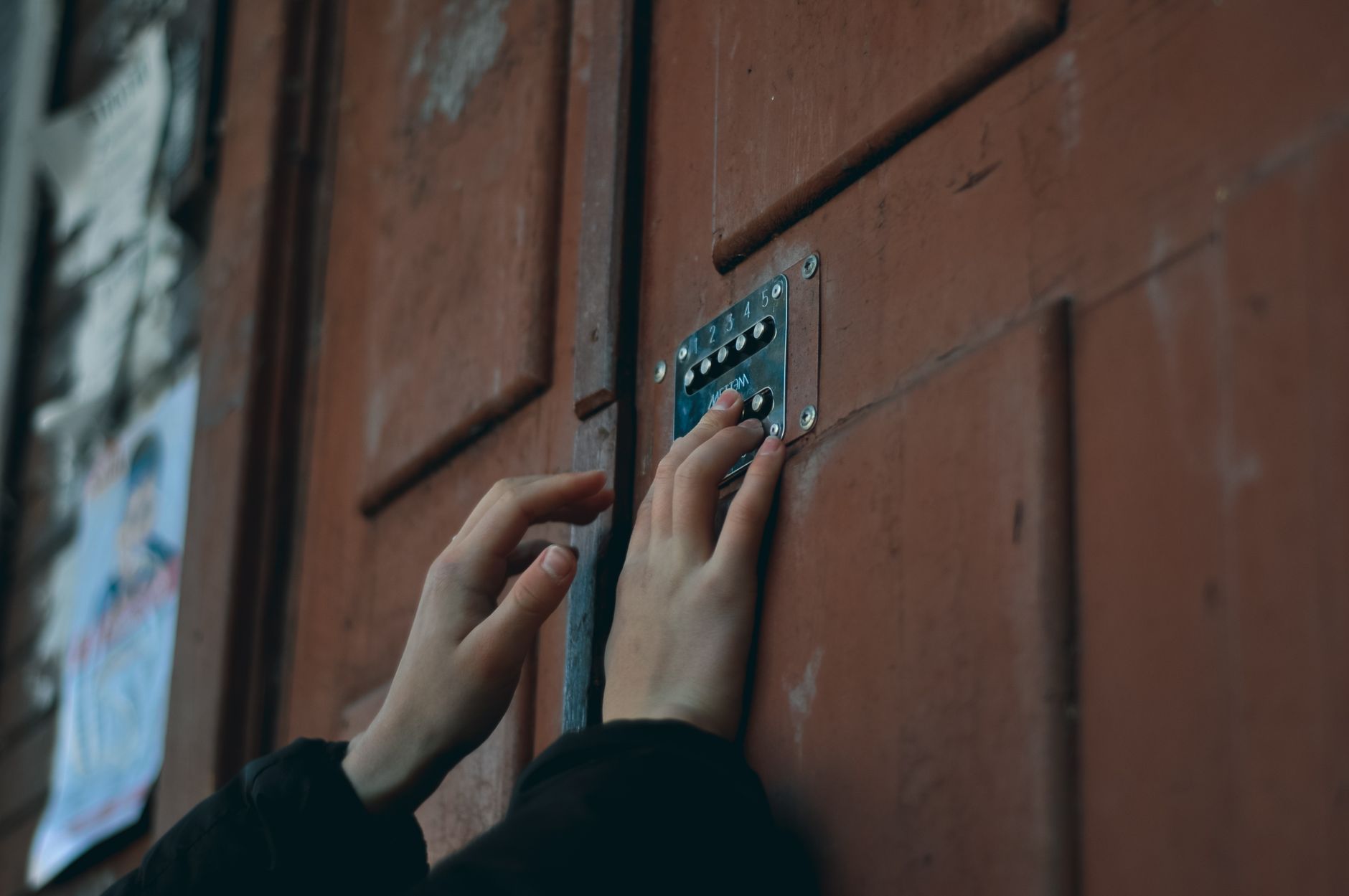 Personne composant un code sur un verrou à combinaison mécanique pour ouvrir une porte