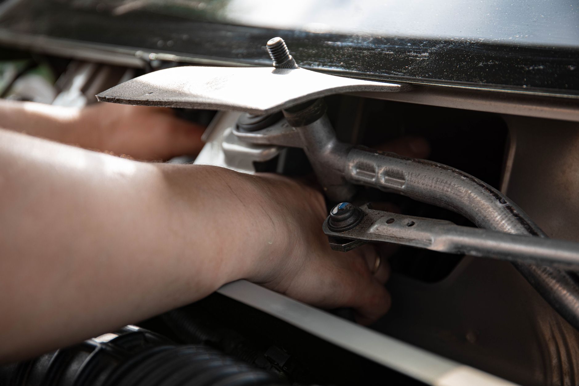Mains d'un technicien remplaçant le mécanisme de serrure d'une porte de garage