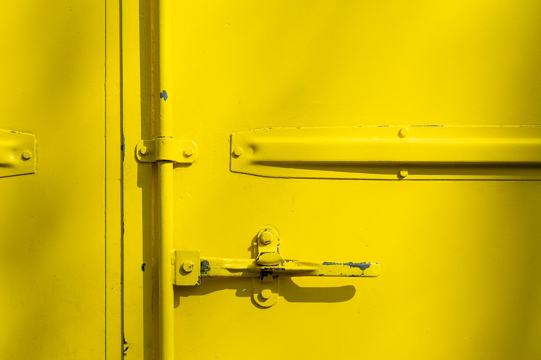 Gros plan sur un verrou de porte métallique peinte en jaune