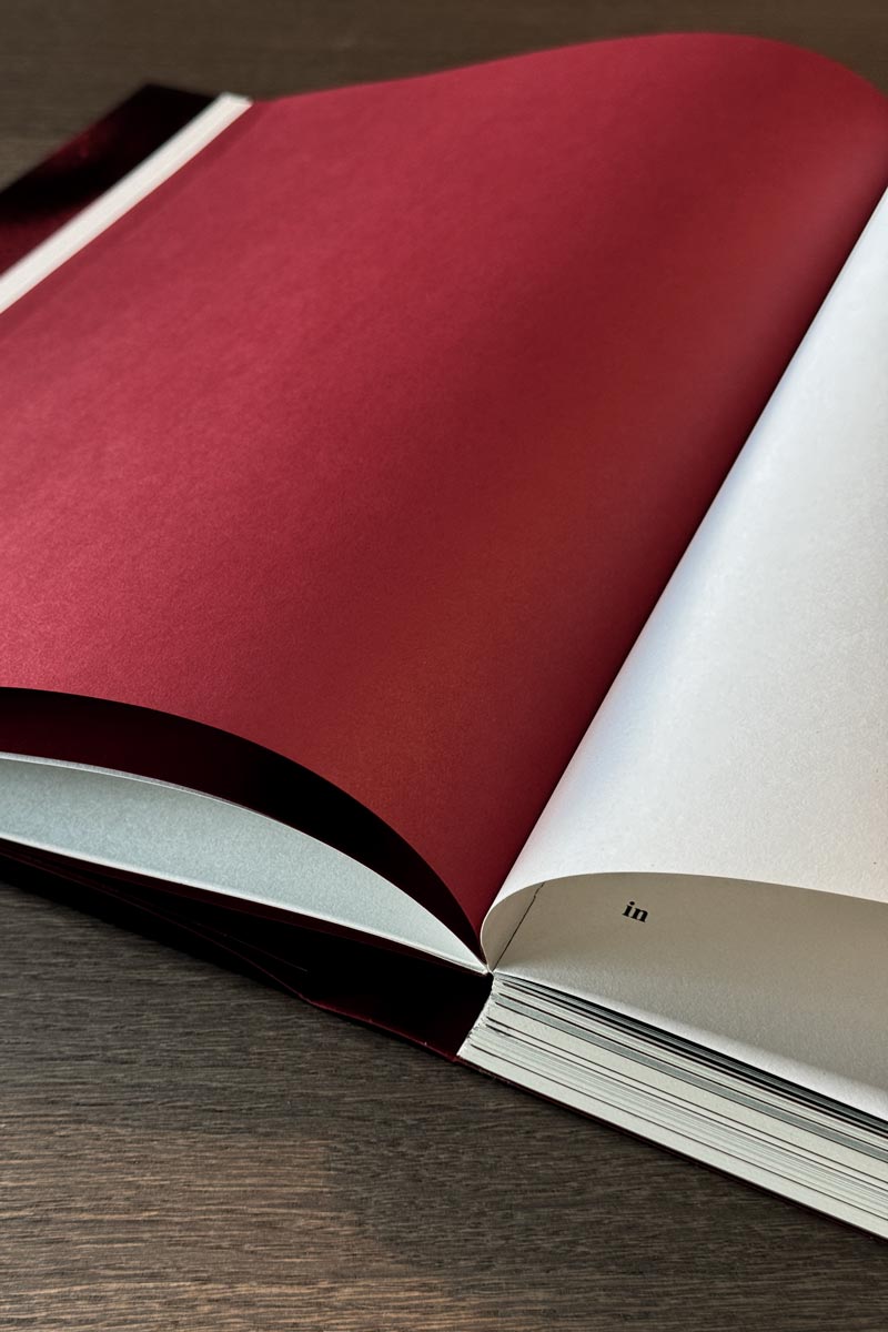 Offenes Buch mit roter und weißer Seite – Buchgestaltung von Wuor Designstudio