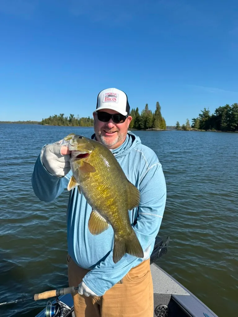 Smiling angler holding a smallmouth bass on Eagle Lake