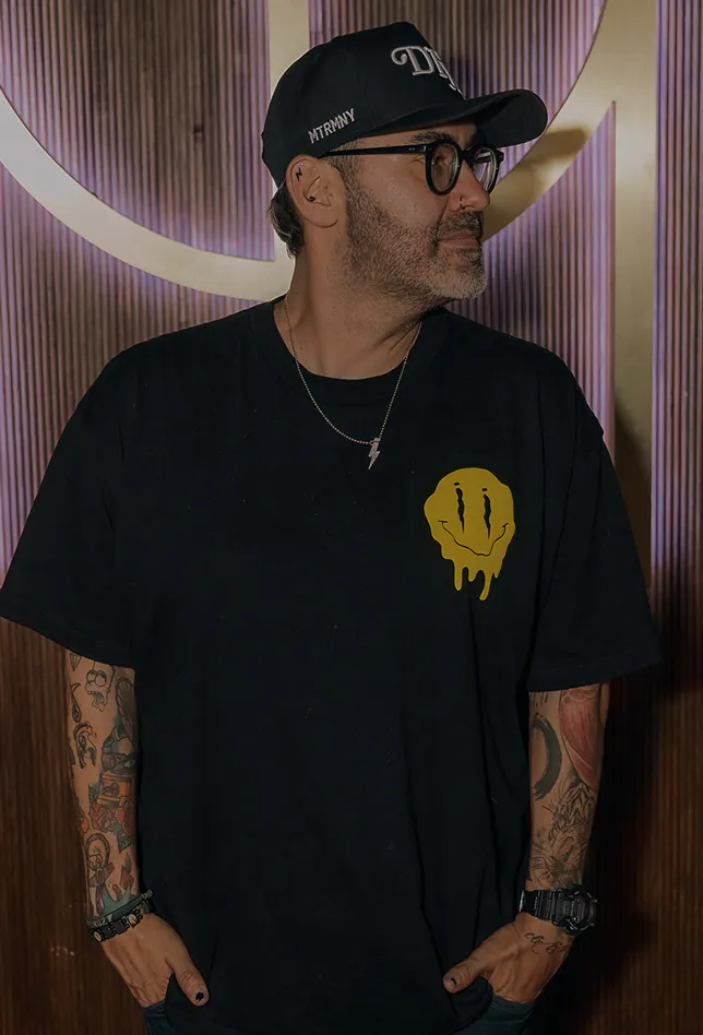 Man wearing a black t-shirt and cap indoors