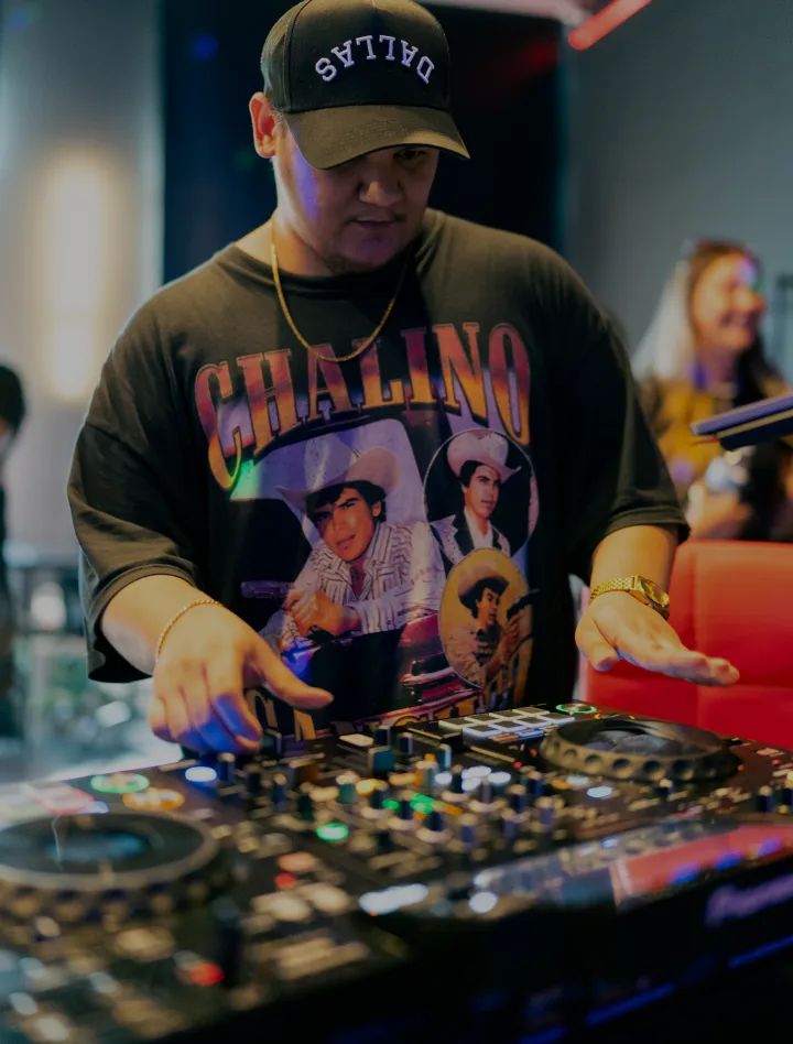 DJ performing on a controller under club lighting