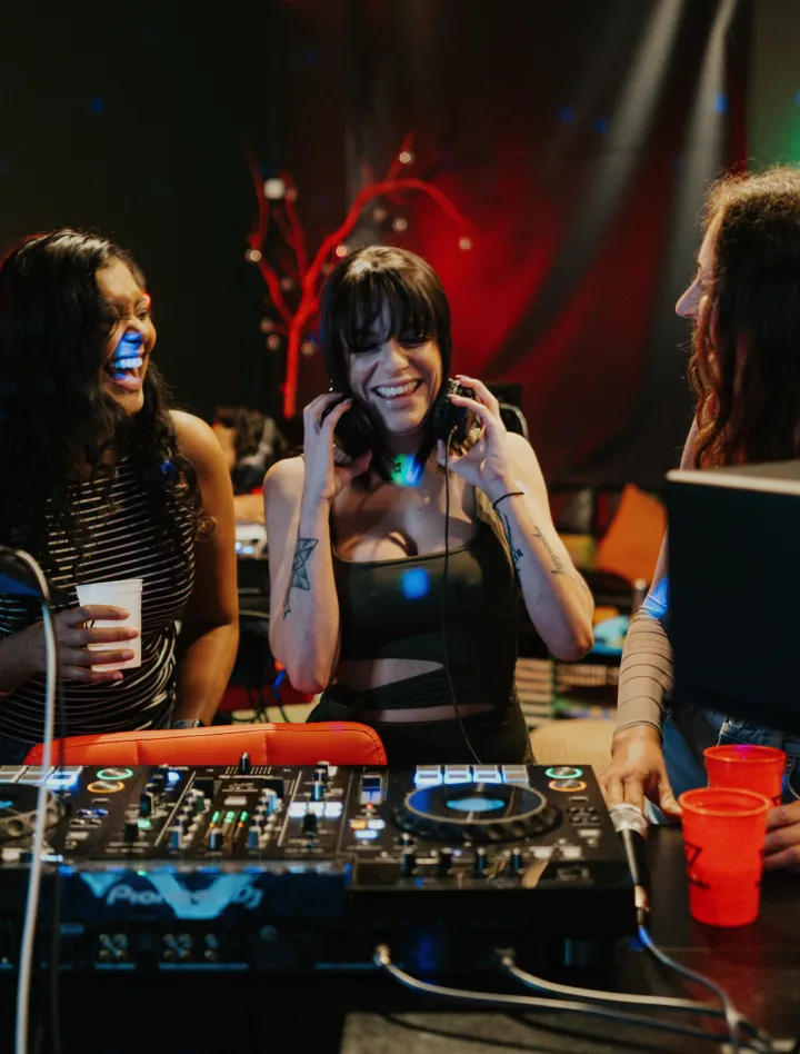 Group enjoying music and laughing near DJ booth