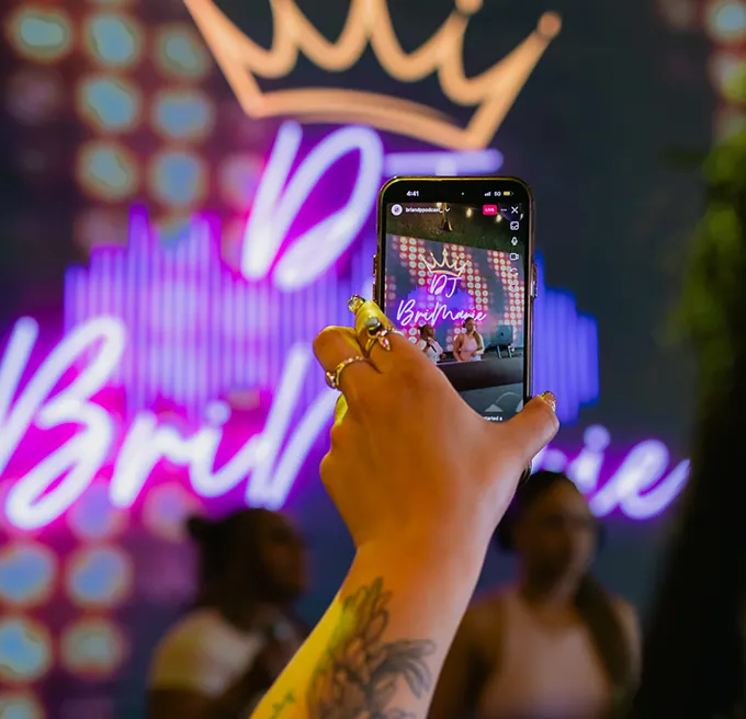 Person recording a DJ event on a smartphone
