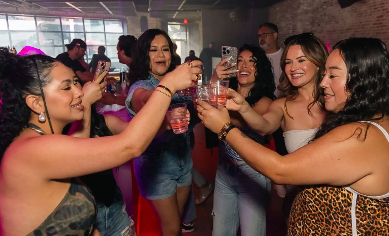 Friends clinking drinks and celebrating at a party