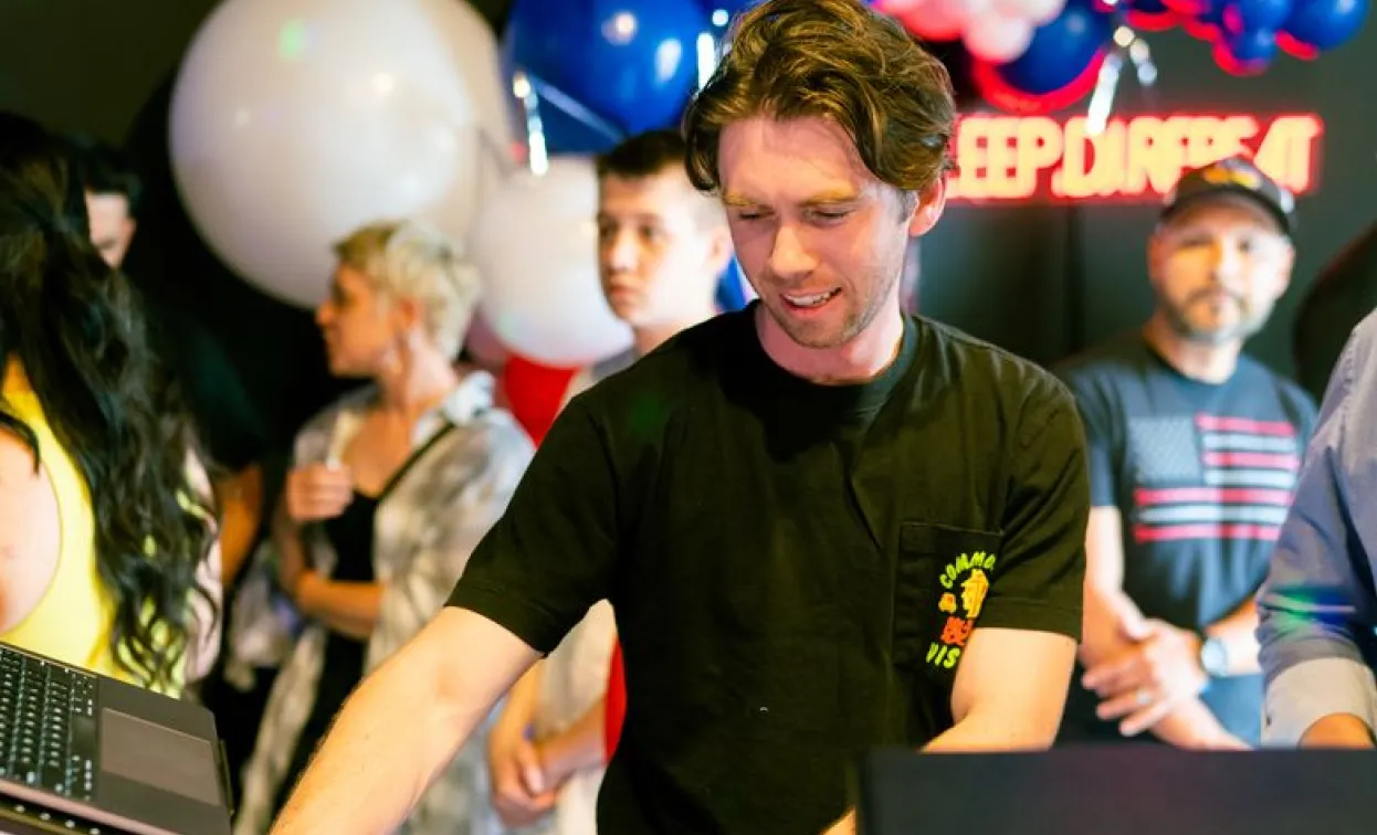 DJ adjusting controls on a laptop during an event