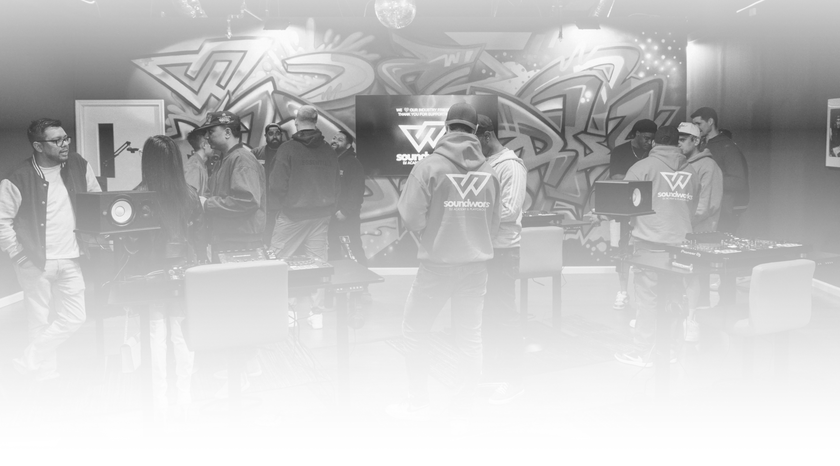 People socializing inside a DJ studio in black and white