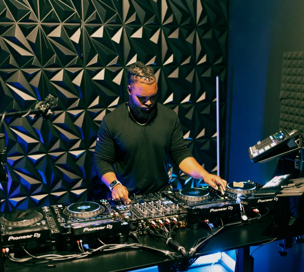 DJ performing on Pioneer equipment in a studio