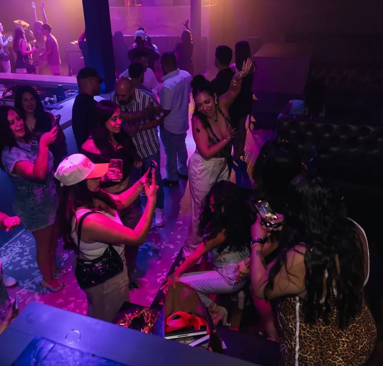 Crowd dancing and recording moments at a nightclub