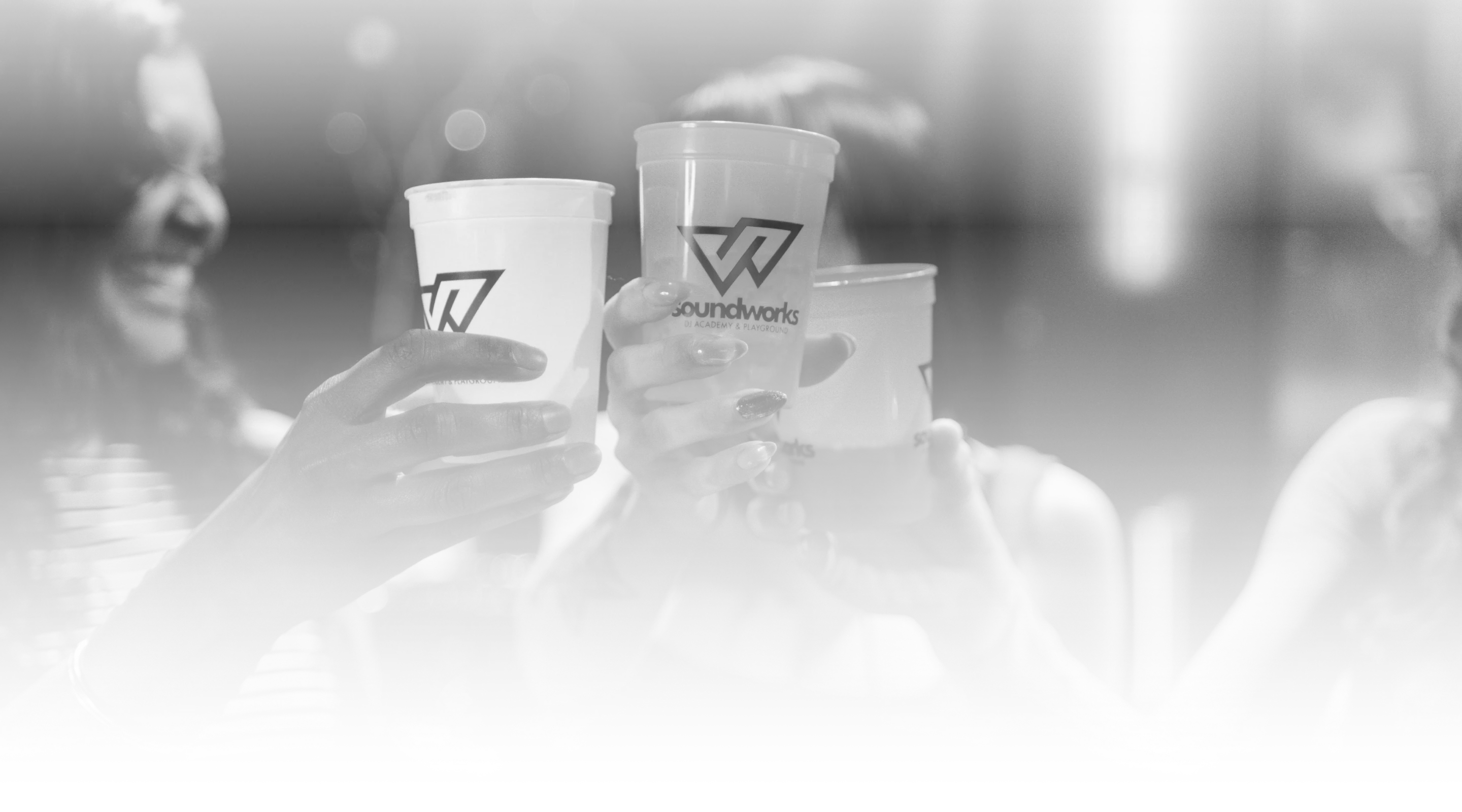 Friends clinking Soundworks cups in a celebratory toast