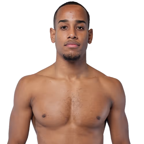 Shirtless young man with a short beard and closely cropped hair looking straight ahead.