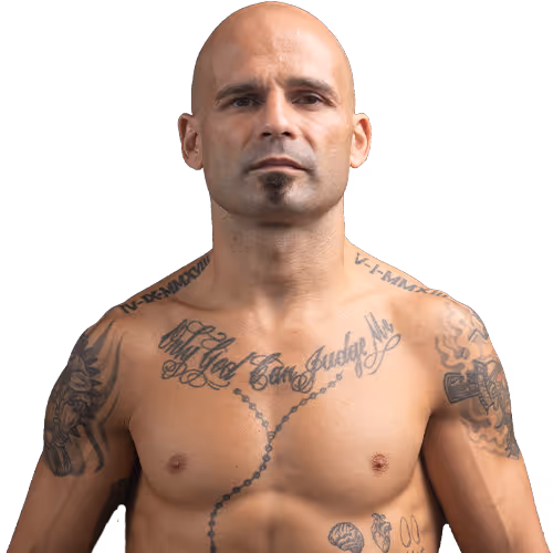 Shirtless bald man with goatee and multiple tattoos on chest and arms.