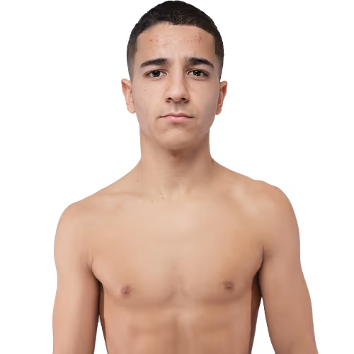 Young shirtless man with short dark hair looking directly at the camera against a white background.