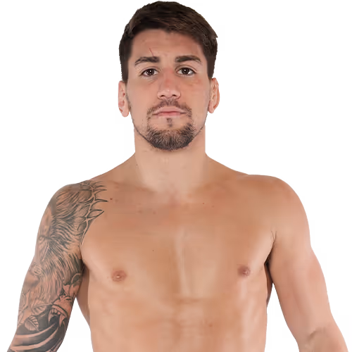 Shirtless man with a tattoo sleeve on his left arm, short dark hair, and a trimmed beard, facing forward.
