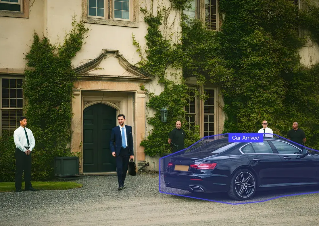 Businessman in a suit carrying a briefcase walking from a large building entrance with four security guards and a black luxury car parked nearby.