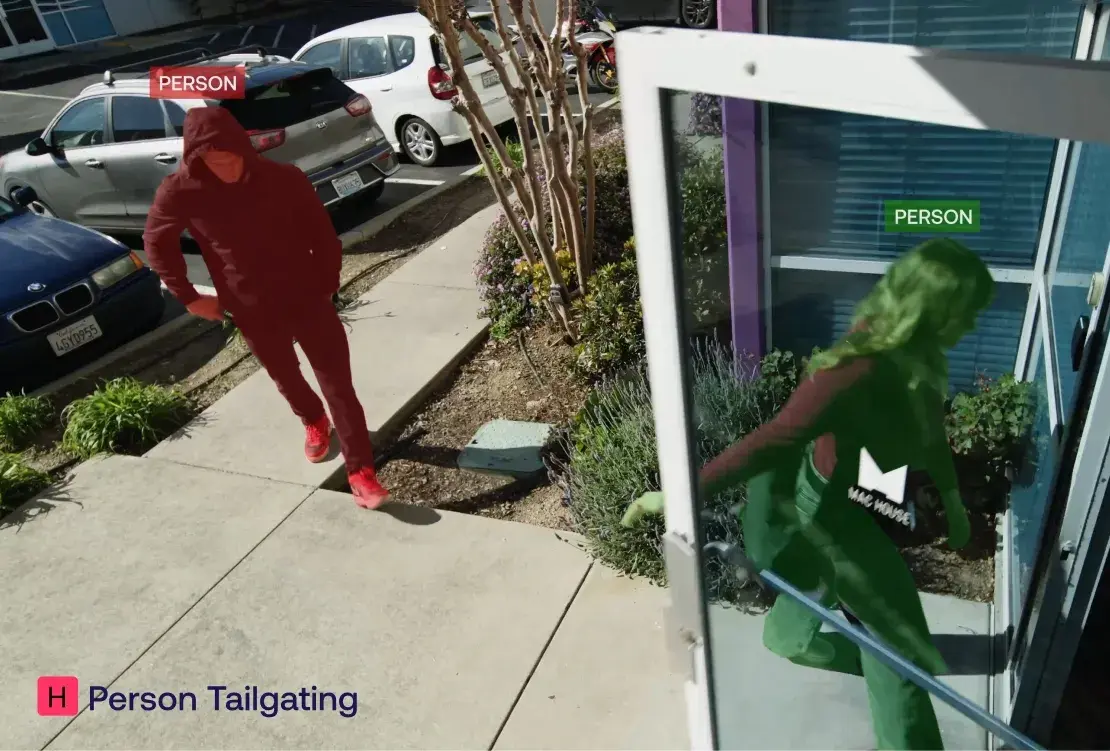 Image of a person entering a building while another person follows closely behind on the sidewalk labeled 'Person Tailgating'.