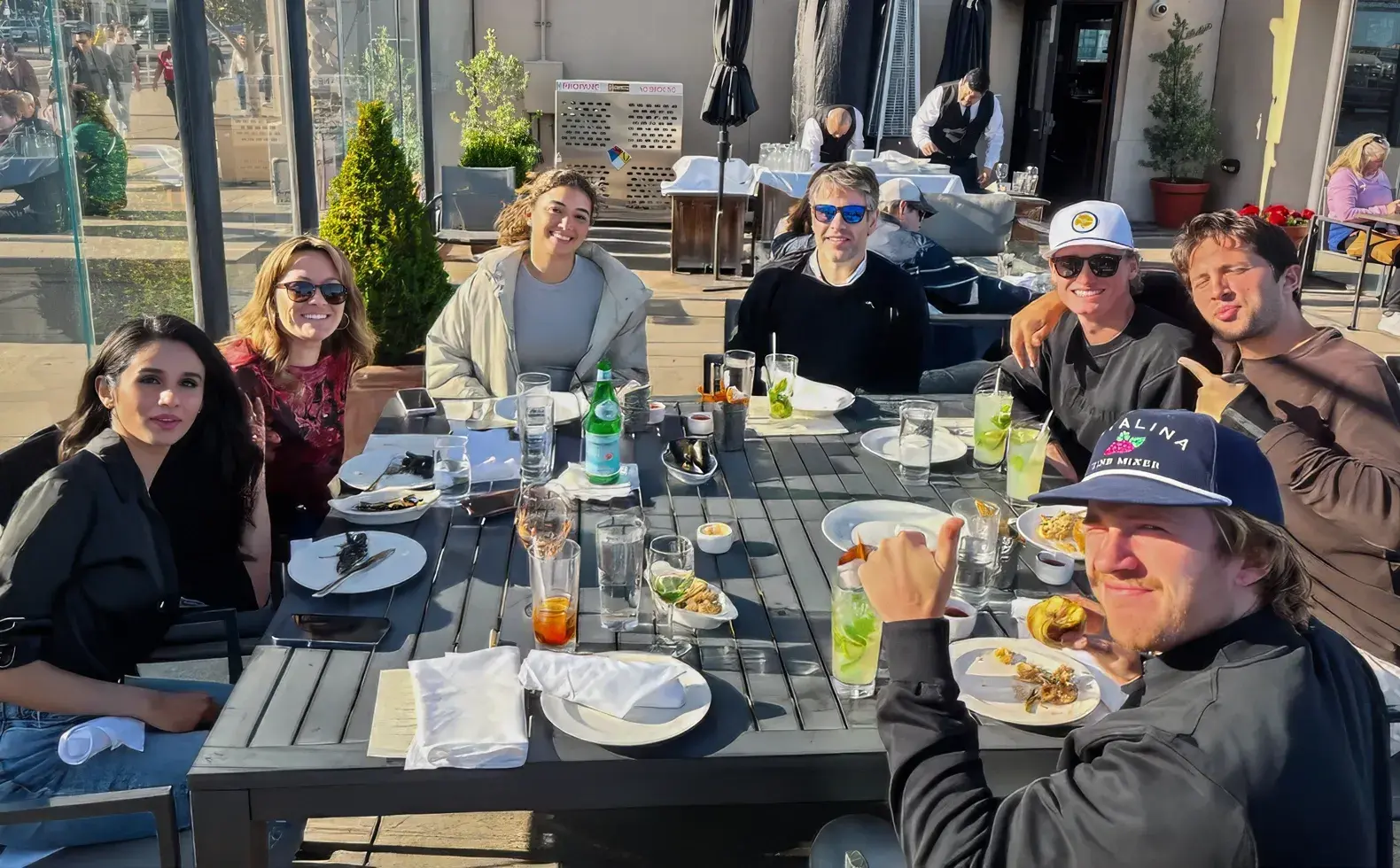 A group of people sitting around a table eating food.