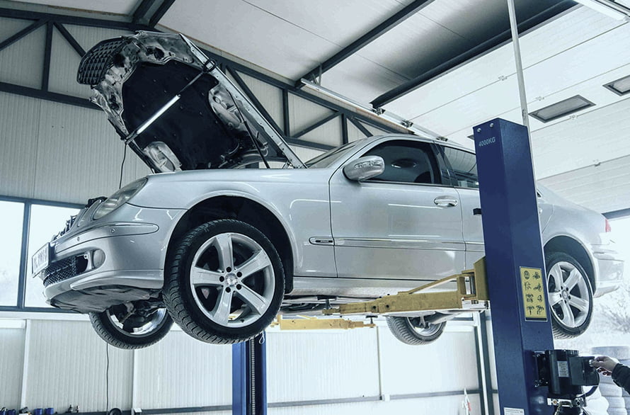Automobil na dizalici tokom tehničkog pregleda i održavanja u auto servisu Sapfir Auto.