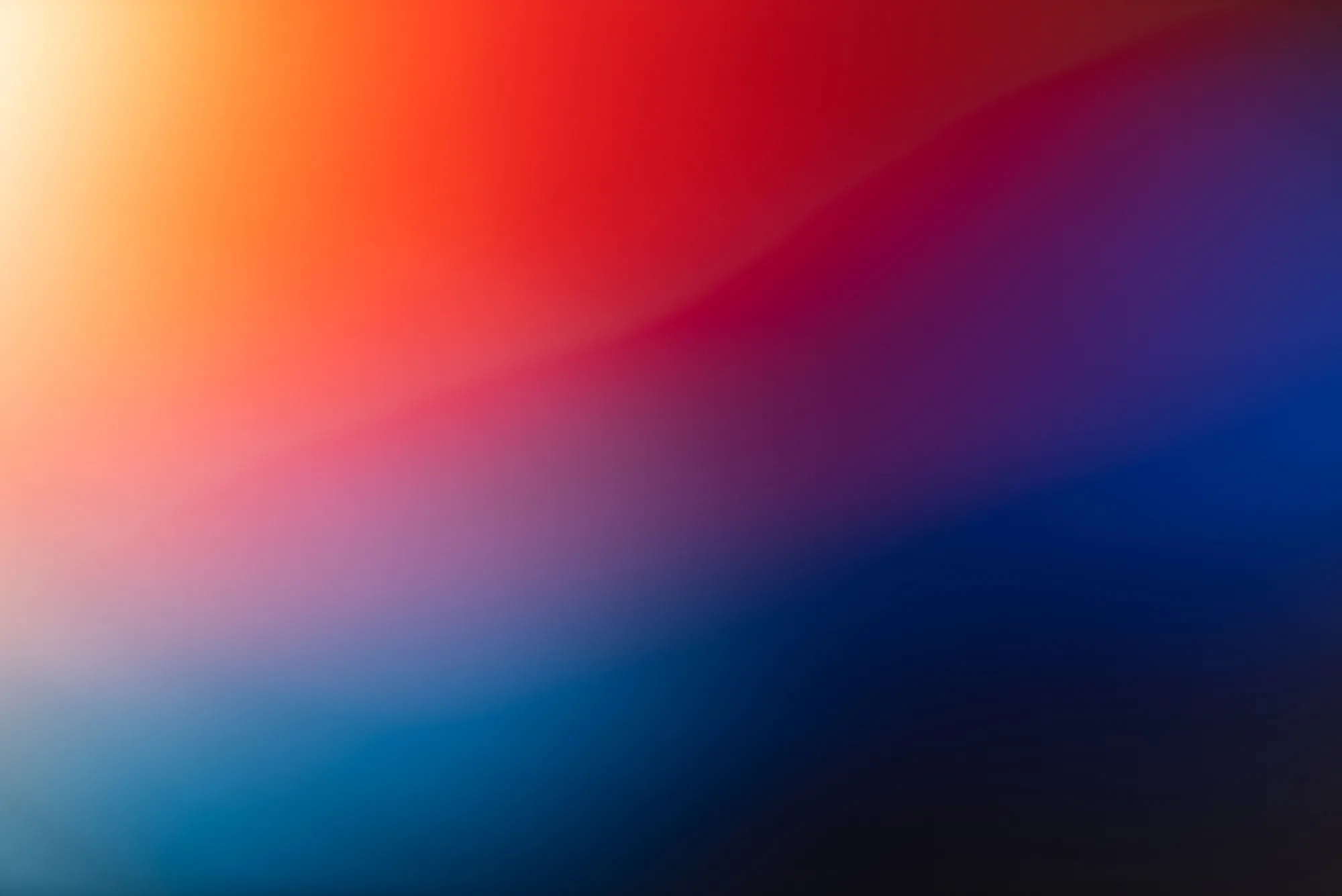 Abstract gradient background blending warm orange and red hues into cool purple and blue tones.