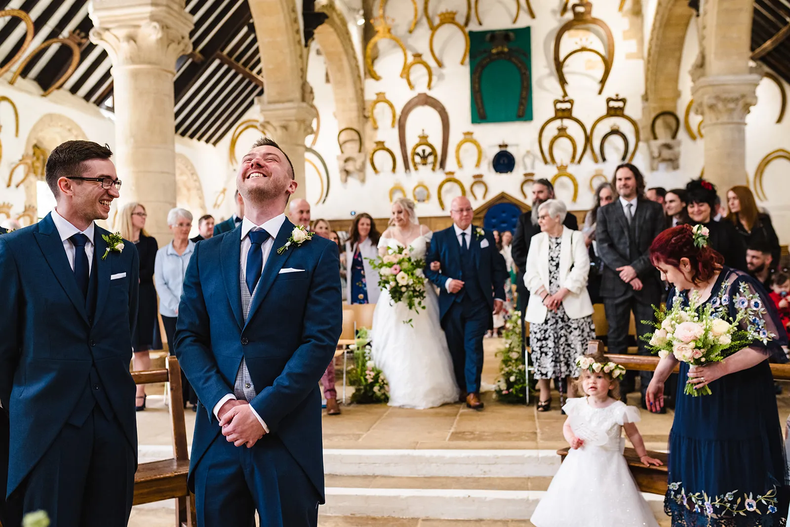 Groom wearing a morning suit waiting for his bride to be walking down the aisle. 