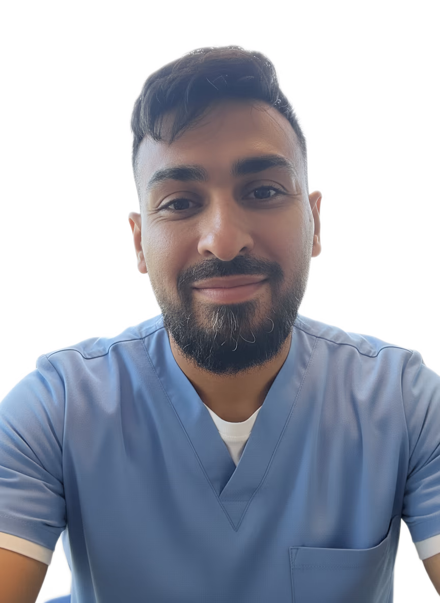 Smiling man with dark hair and beard wearing a light blue medical scrub top.
