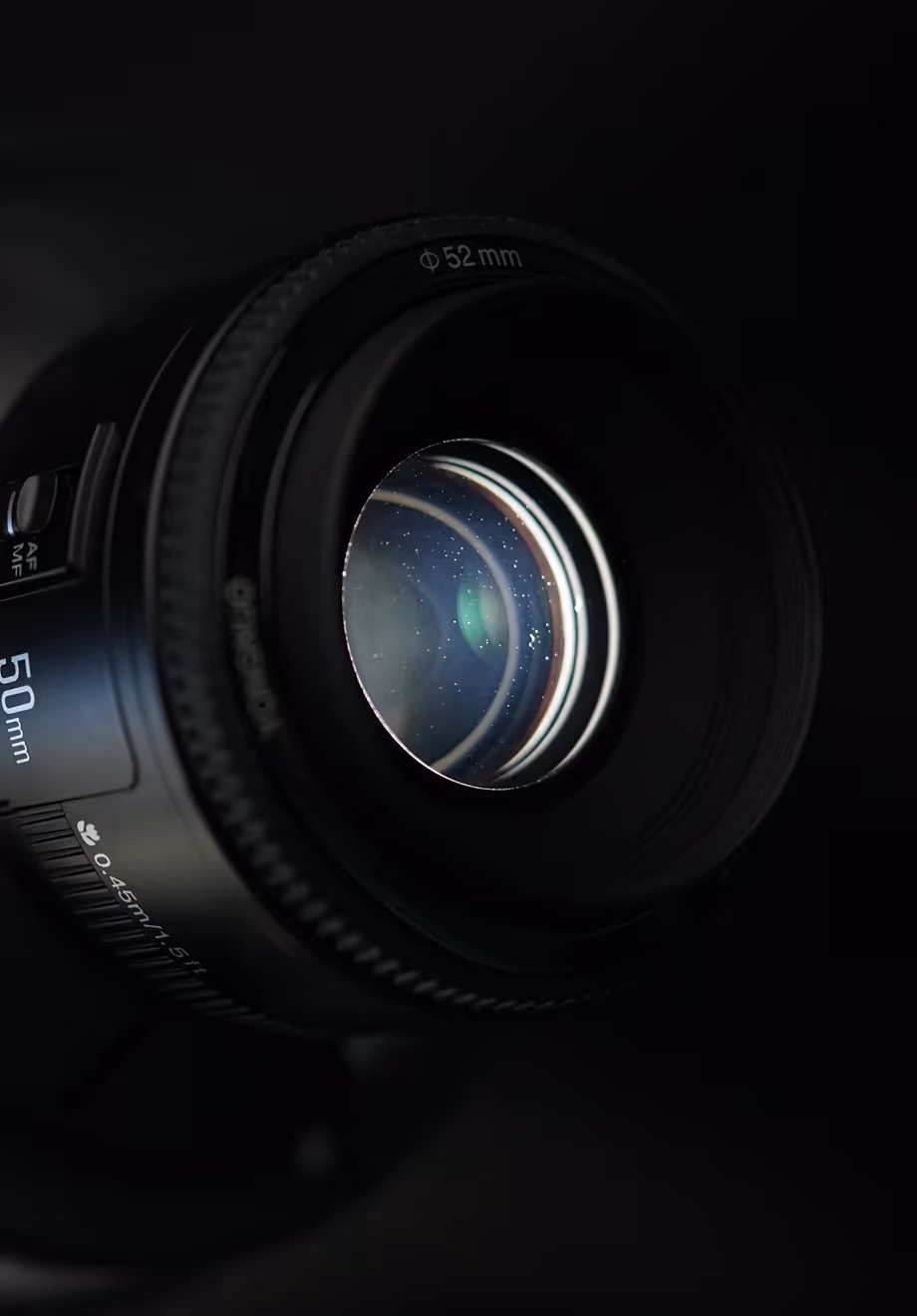 Objectif d'appareil photo 50 mm avec mise au point automatique désactivée sur fond noir.