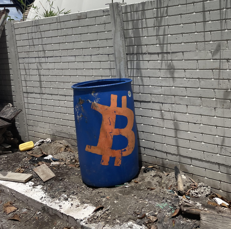 A blue barrel with a bitcoin symbol on itDescription automatically generated