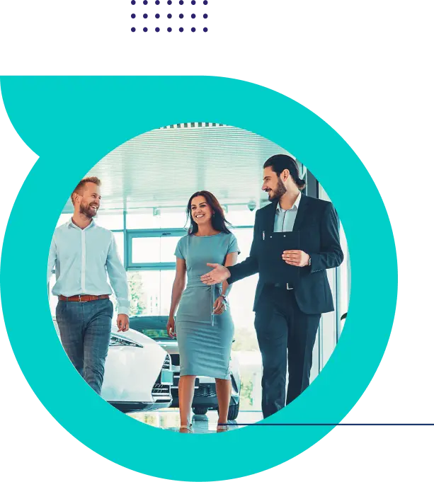 Three business people walking and talking inside a modern office with cars in the background.