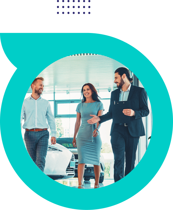 Three business people walking and talking inside a modern office with cars in the background.