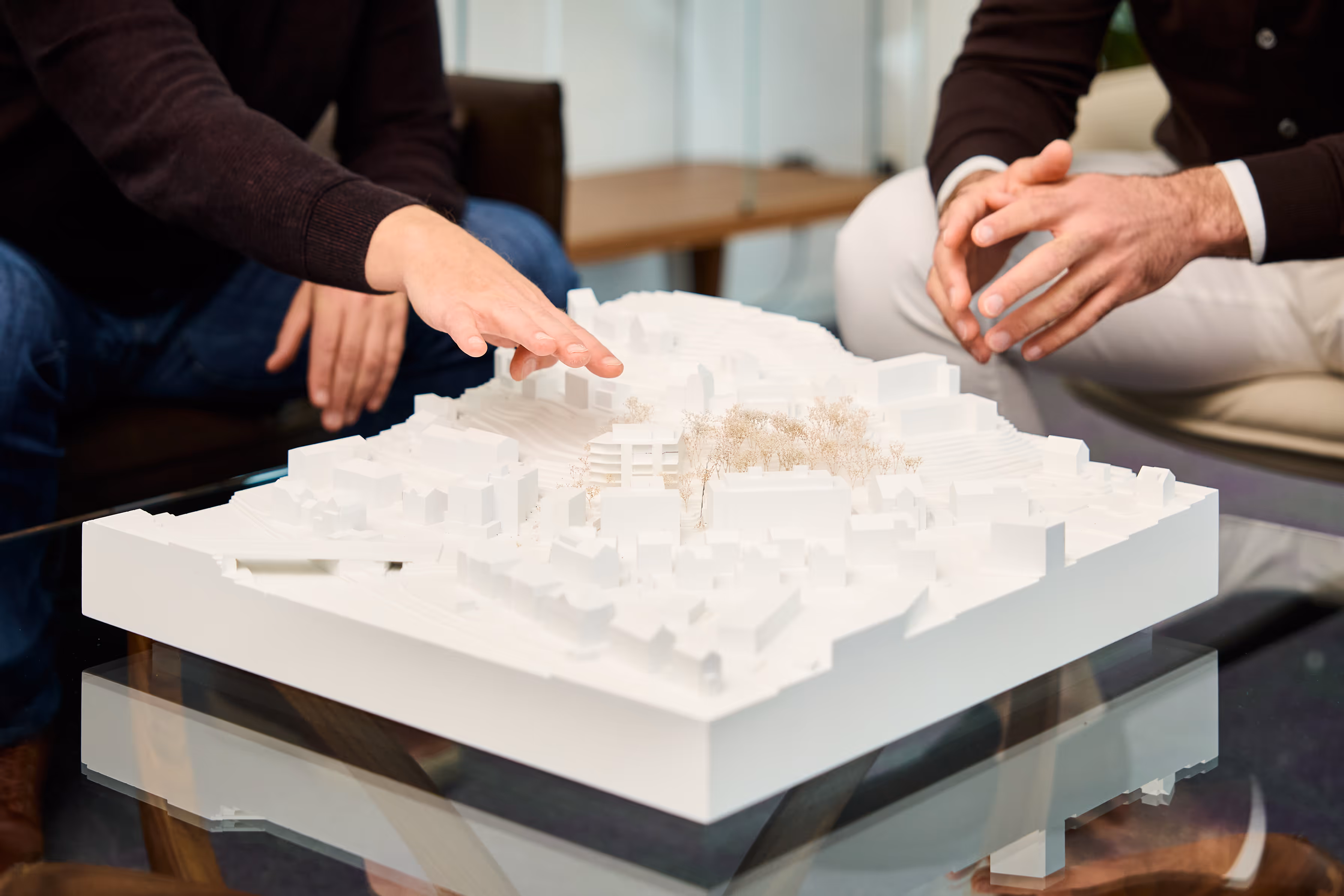 Wild AG - Team diskutiert über Miniaturmodelle eines Bauprojekts