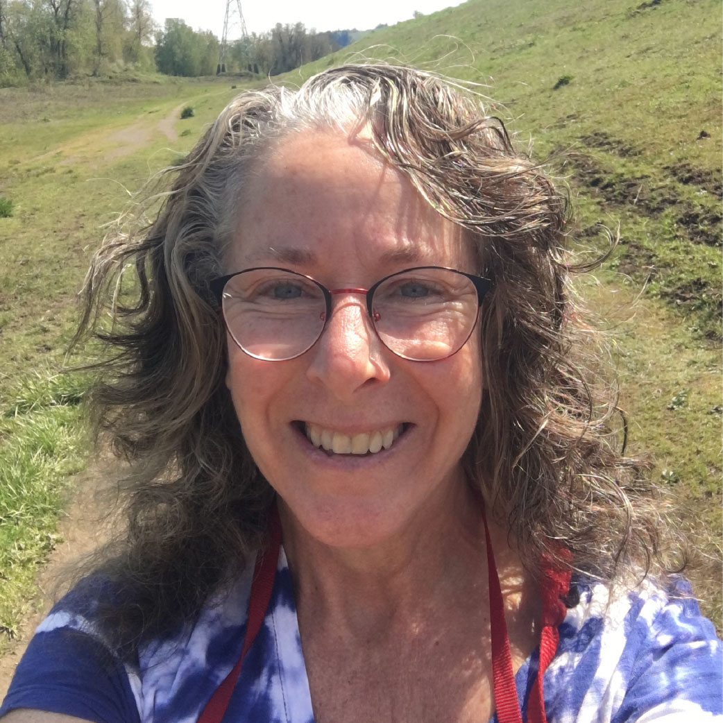 Michelle takes a selfie in a green, forrest enviornment