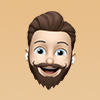 Cartoon avatar of a smiling man with brown hair and beard wearing wireless earbuds.