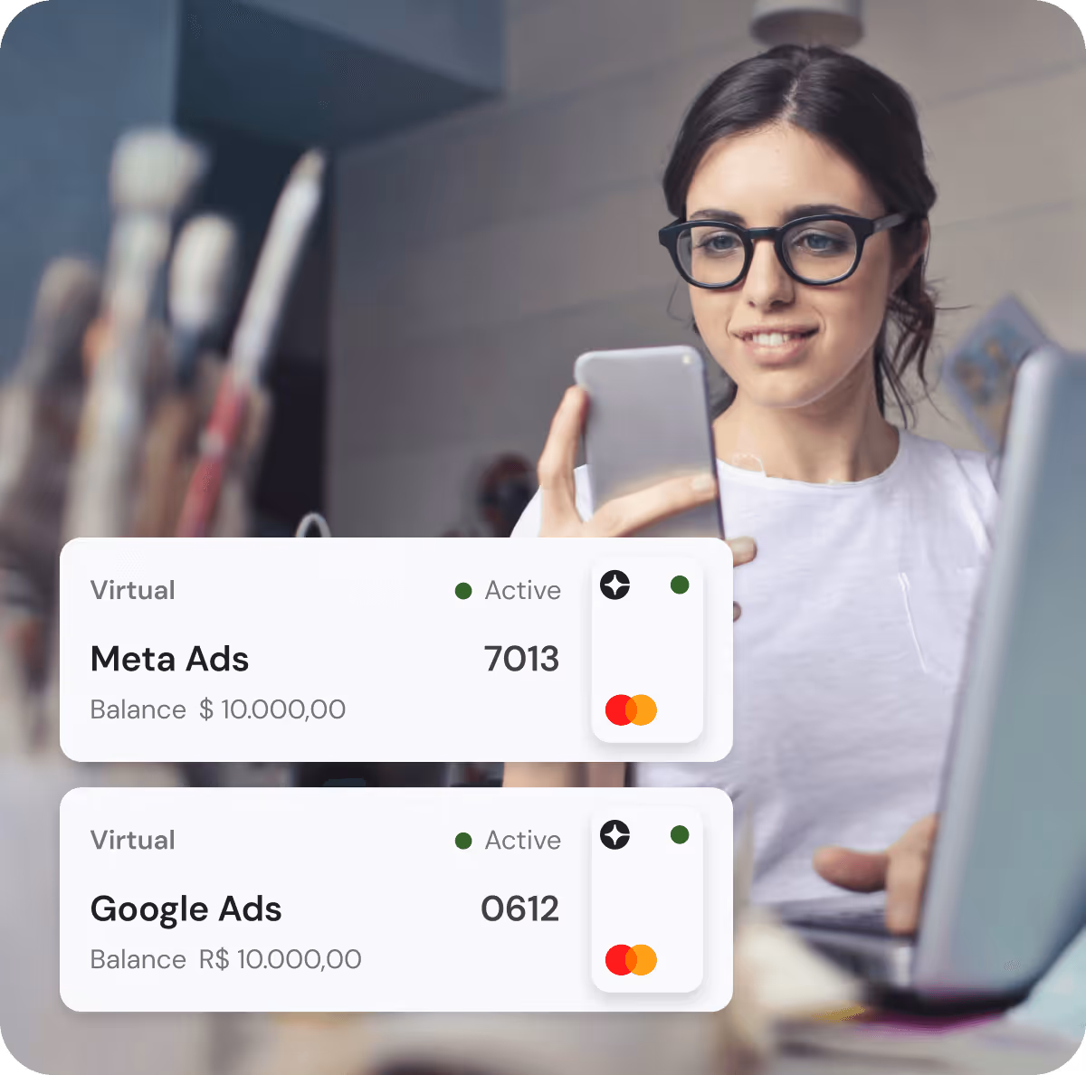 Woman with glasses smiling while looking at her phone next to a laptop, with overlay showing two virtual ad account cards labeled Meta Ads and Google Ads, both active with balances of 10,000.00.
