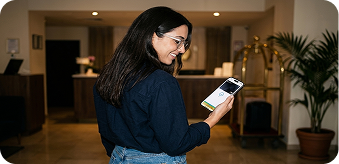 Woman using the Clara app on her phone in a hotel lobby