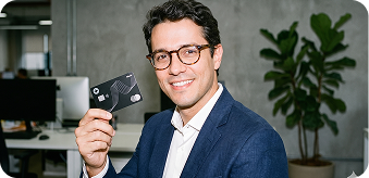 Man in a suit holding a black Clara corporate card