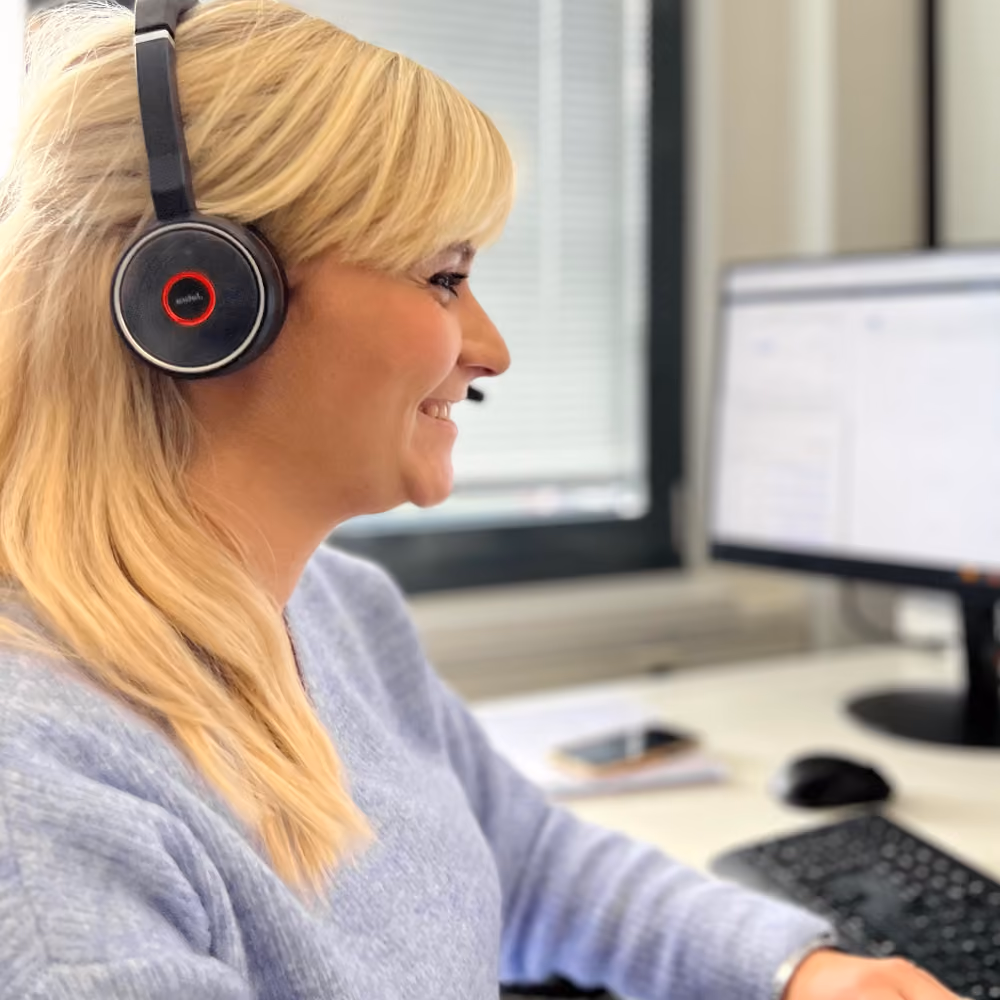 Frau am Schreibtisch mit Headset - Bildmotiv für die Seite zur Karriere im Consulting bei Innovabee