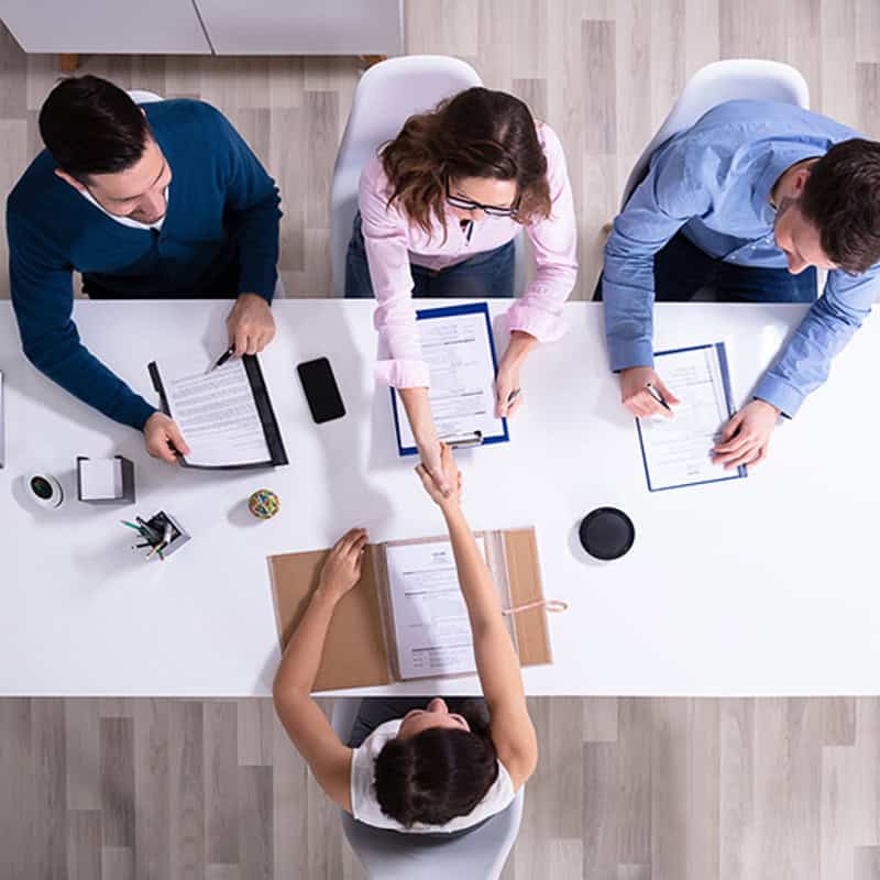 Job candidate shaking hands with a hiring panel during an interview