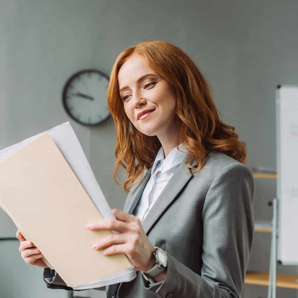 Businesswoman in a suit reviewing documents in an office