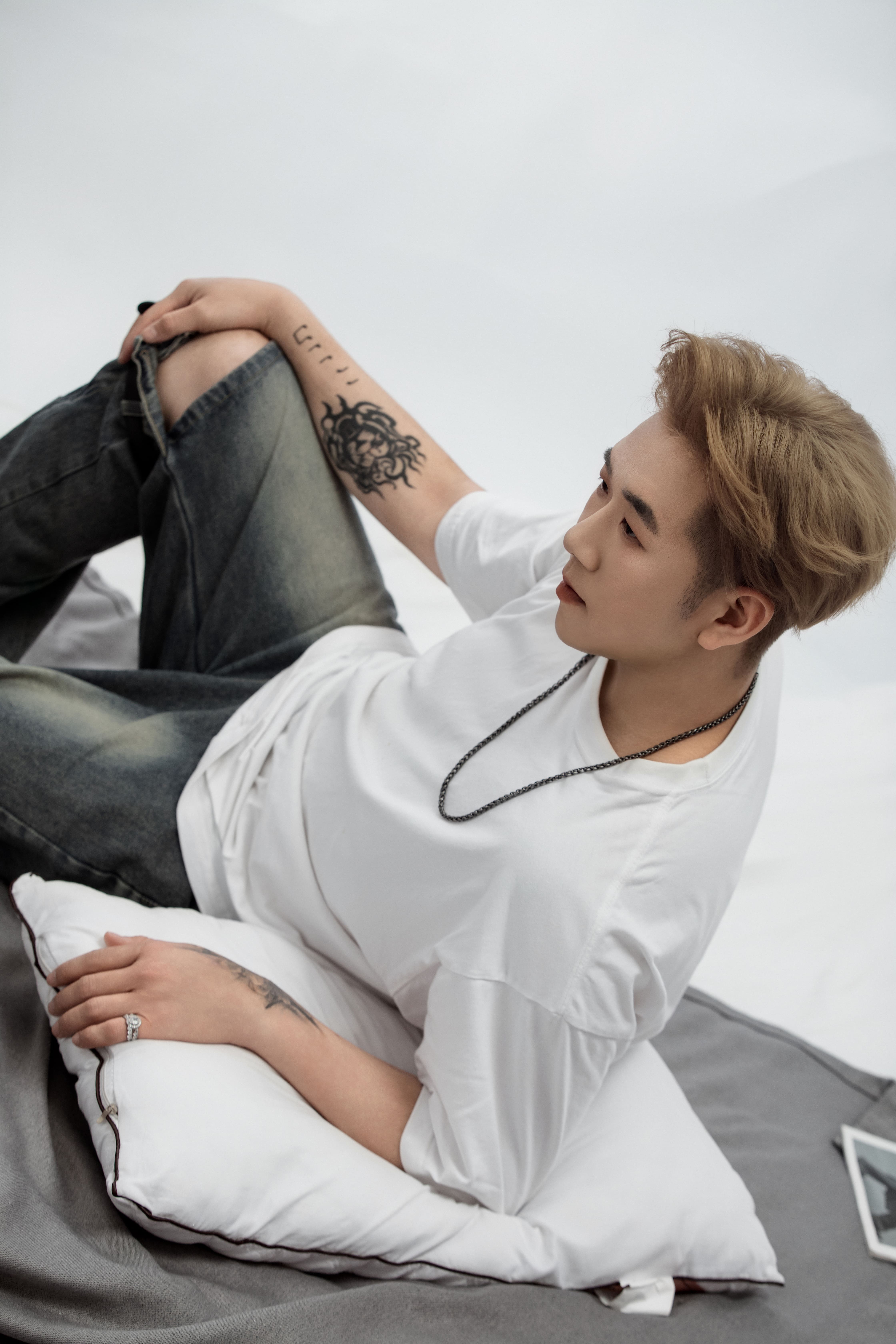 A man rests on a rug, his head turned to the left