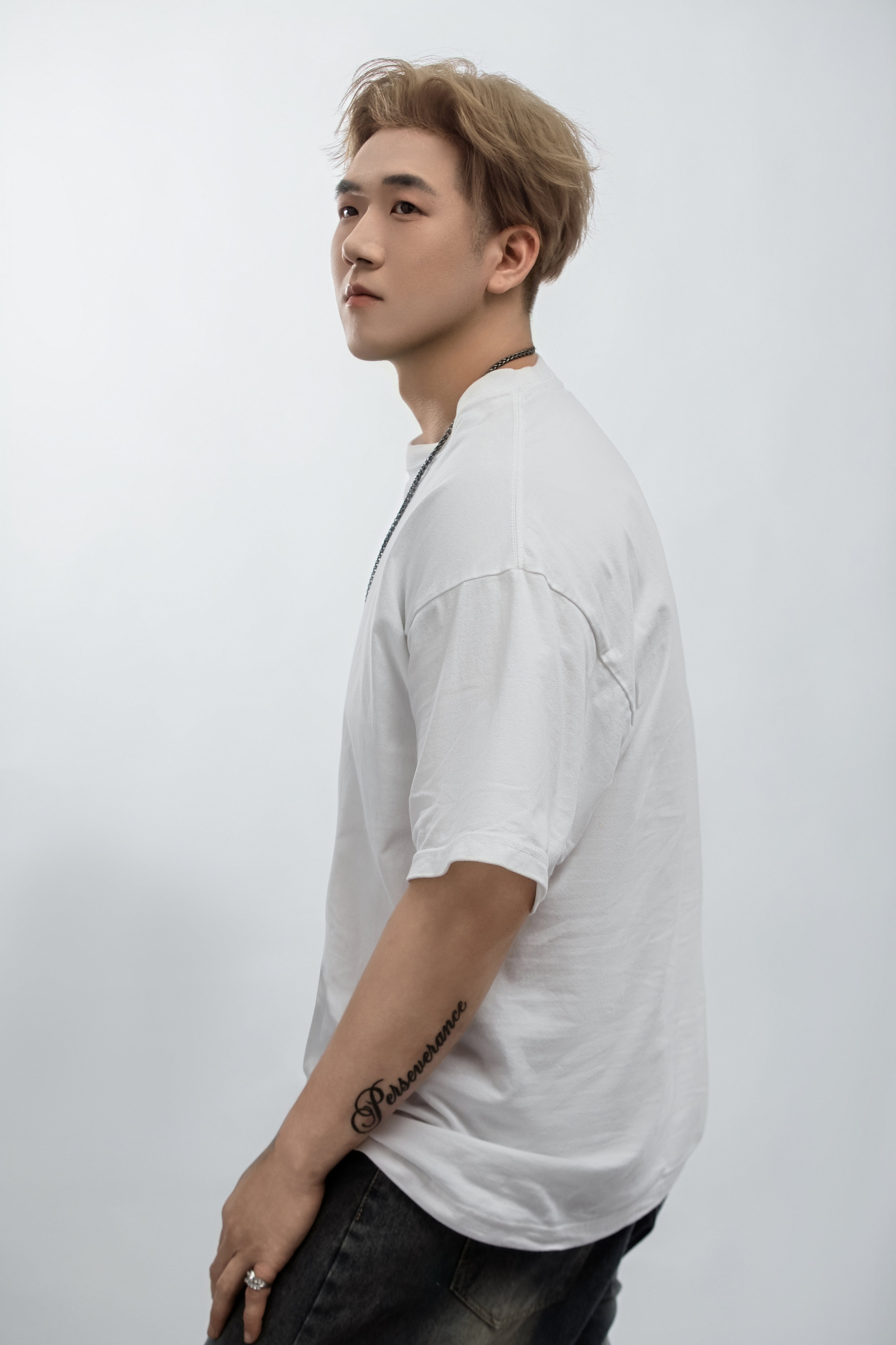 Standing upright, a man gazes off-camera.