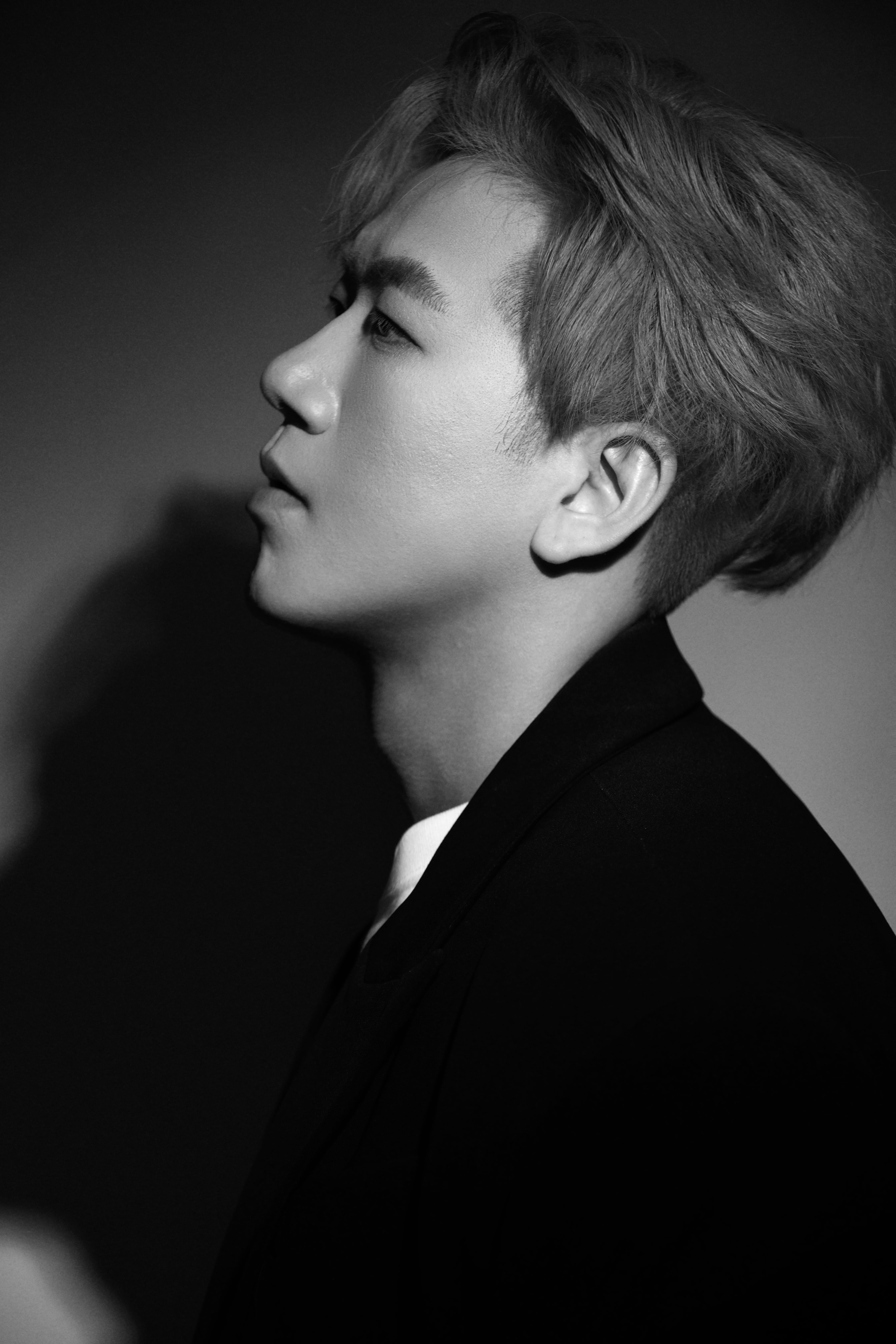 A man poses with his head angled to the side.