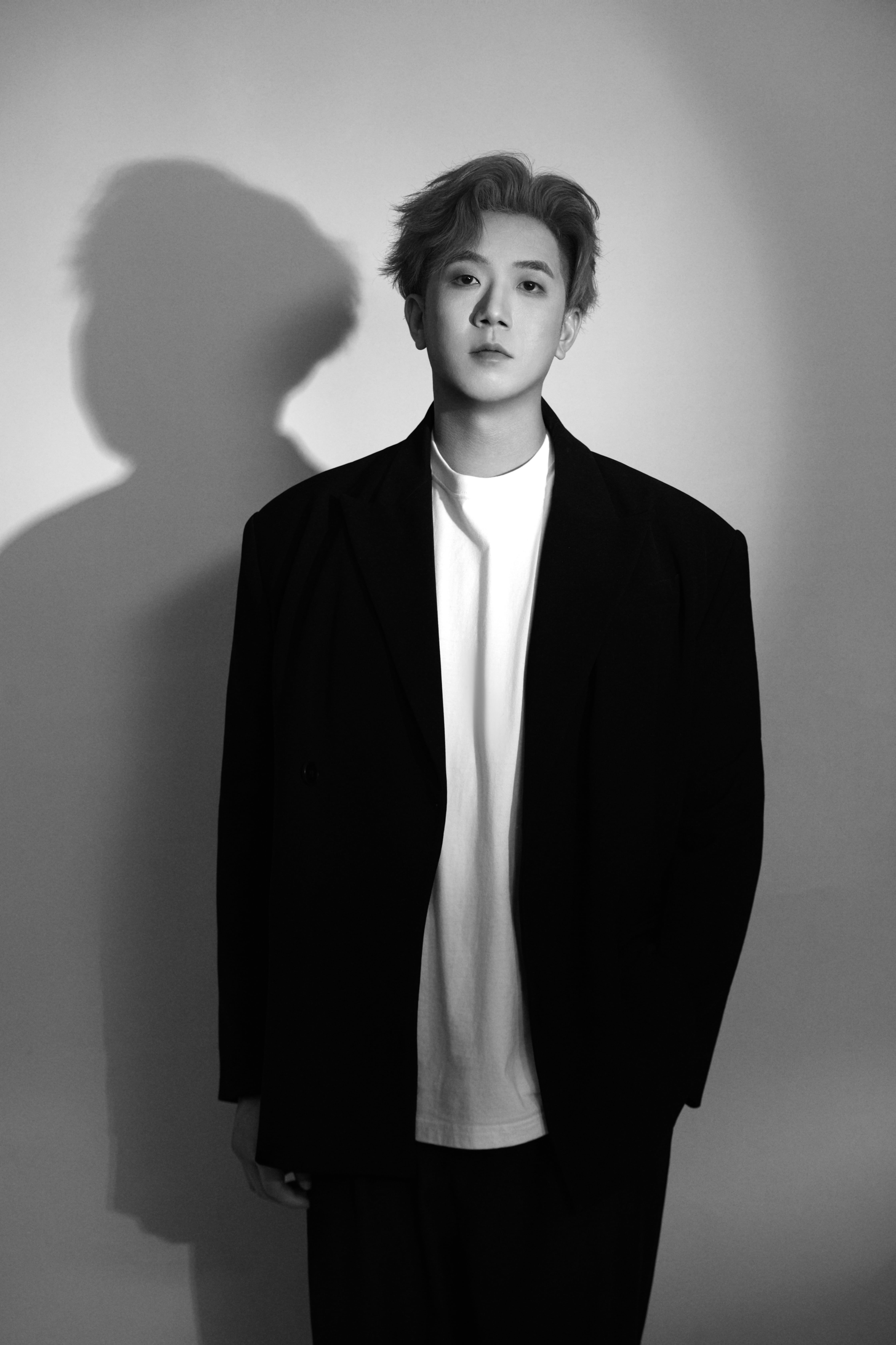 A man poses upright, the scene rendered in black and white.