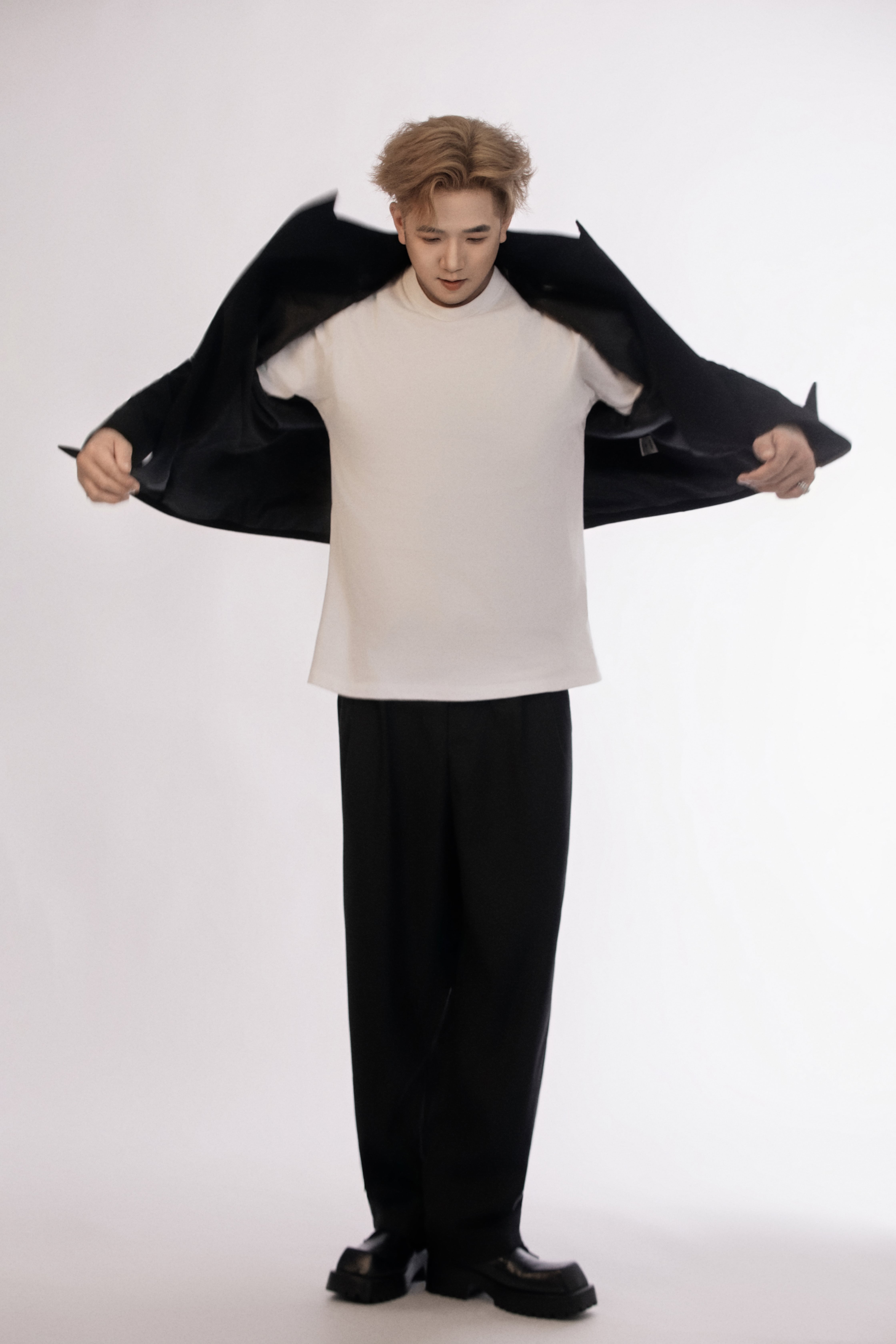 A man drops his jacket and looks down