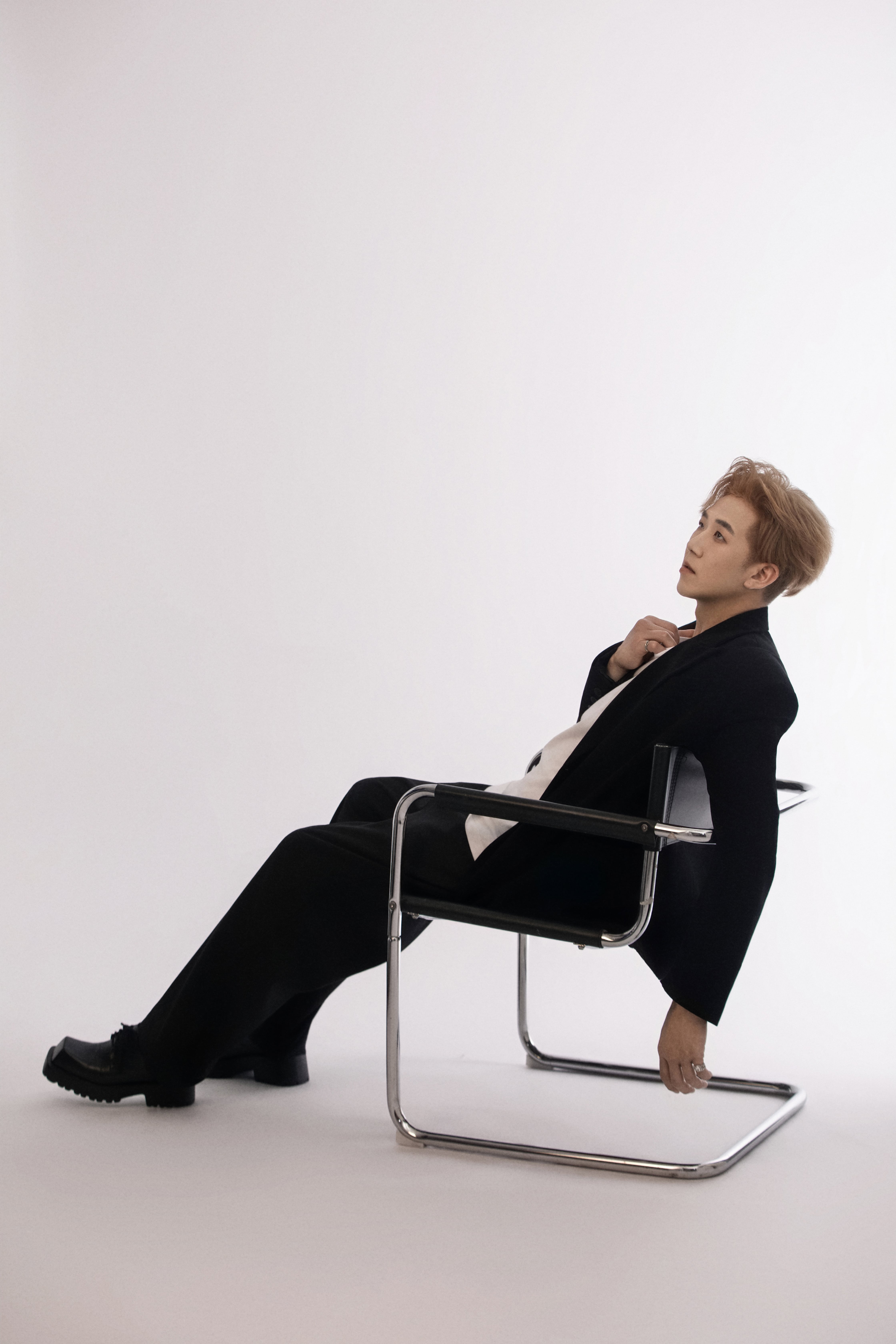 A man leans back on a chair, his arm hanging loosely