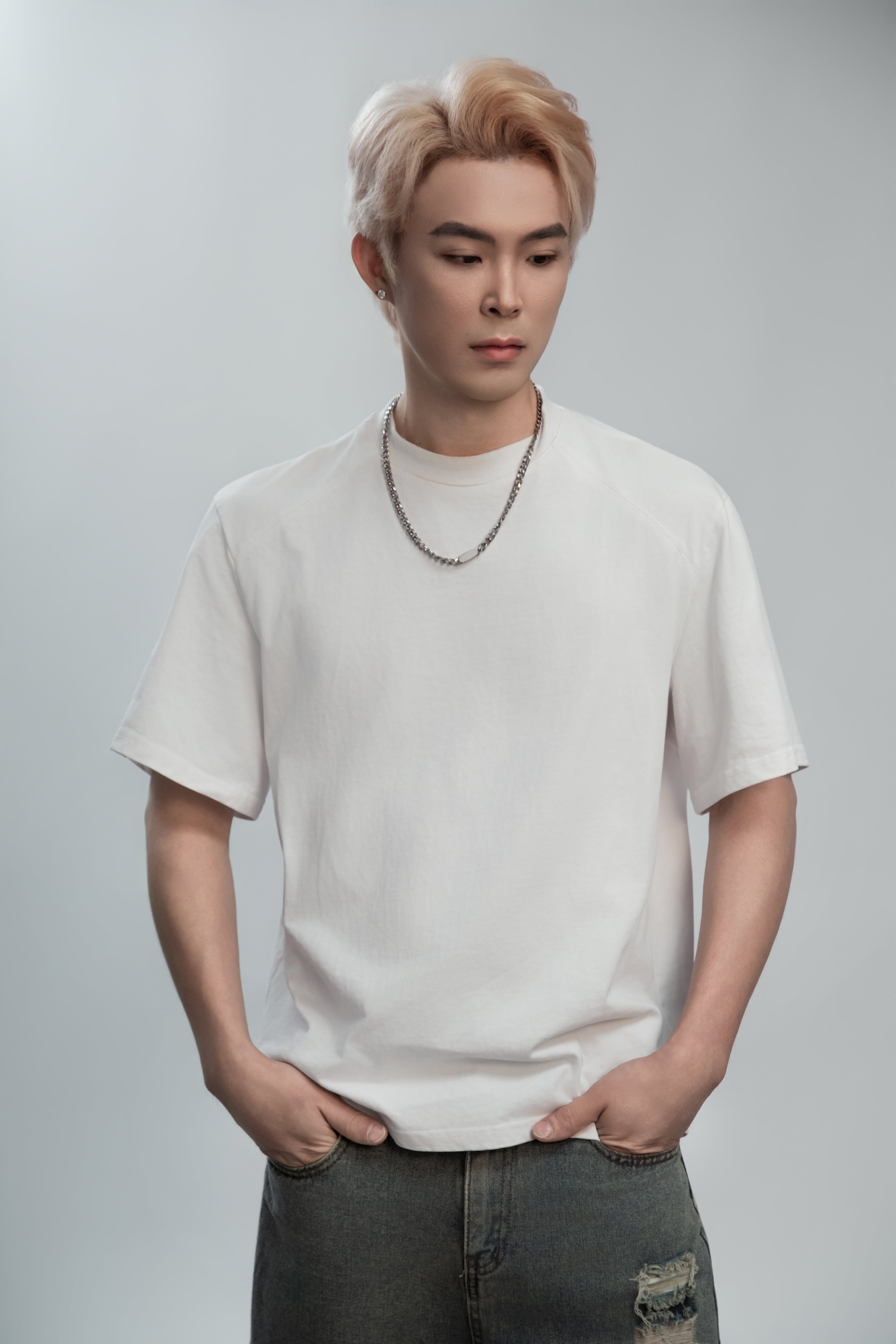 A close-up portrait of a man wearing a white shirt, with a white background