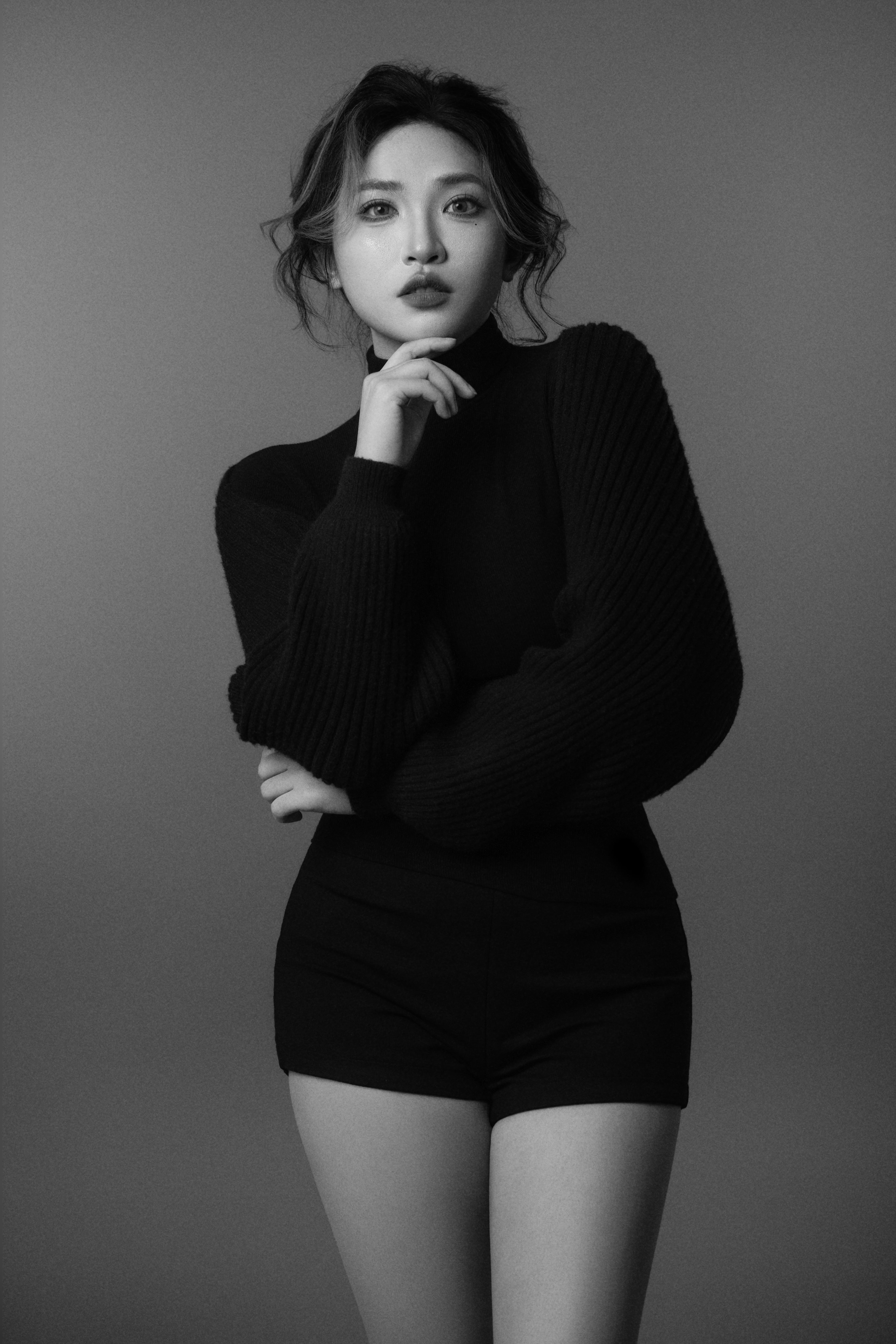 Black-and-white full-body silhouette of a woman posing toward the camera